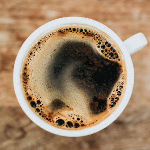 Coffee cup from an aerial view, showing crema bubbling on top.